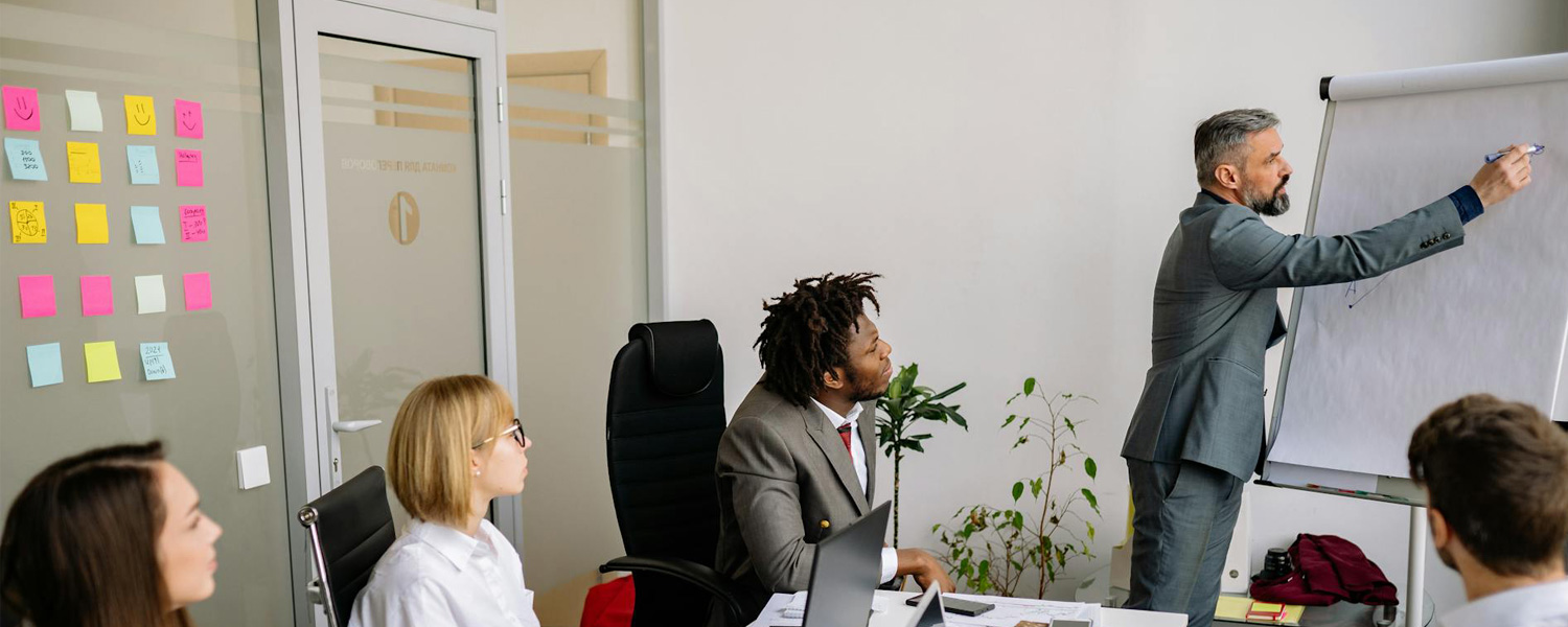 A company's head showing a specific business data to his employees and explaining it